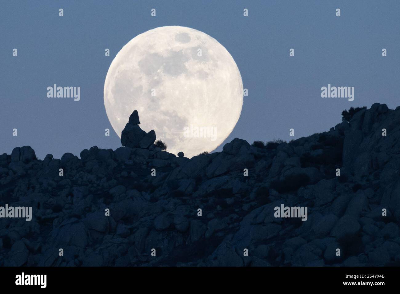 Madrid, Espagne. 13 janvier 2025. La pleine lune de janvier, connue sous le nom de Loup Moon, se lève au-dessus des formations rocheuses de la Sierra de Guadarrama au cours d'une froide nuit d'hiver. Crédit : Marcos del Mazo/Alamy Live News Banque D'Images