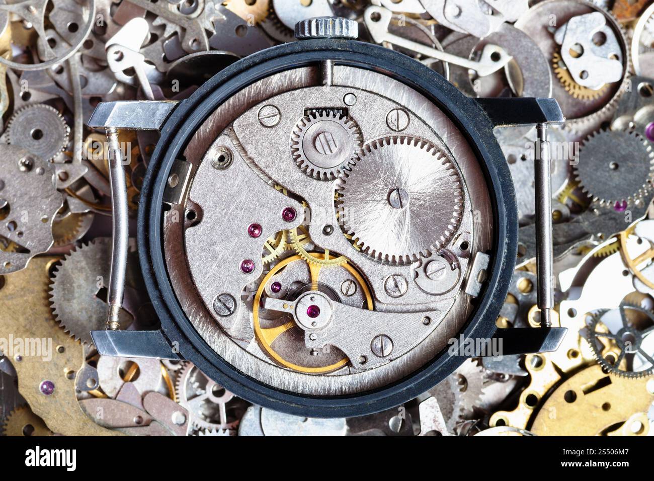 atelier horloger - montre vintage ouverte sur un tas de pièces de rechange d'horloge Banque D'Images
