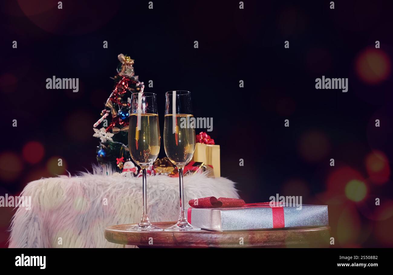 Noël ou Nouvel An fête personnes mains avec verres de cristal pleine de champagne près de l'arbre de Noël et de l'espace pour votre texte Banque D'Images