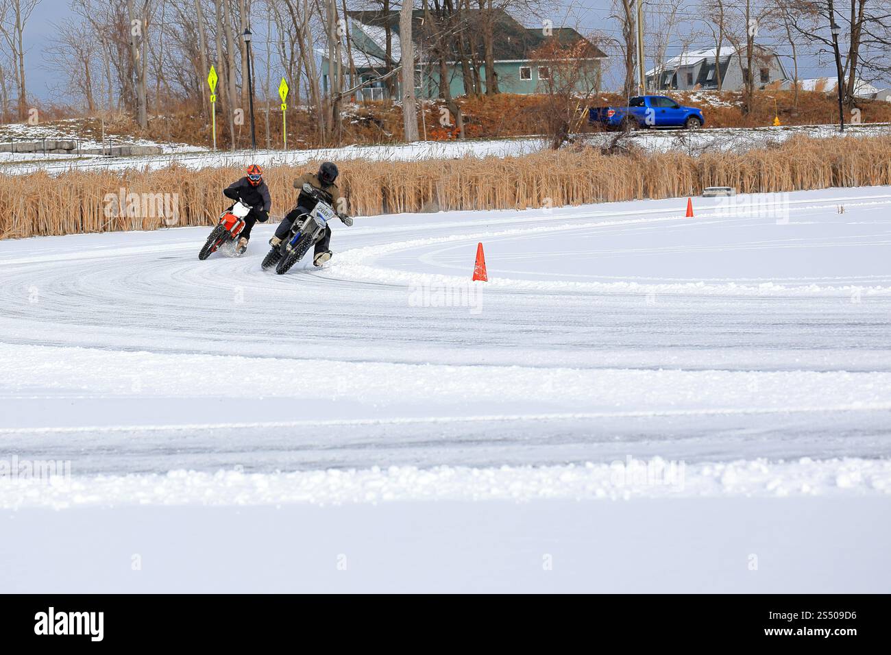 Webster, NY, USA - 11 janvier 2025 - les motards courent autour d'un circuit de glace dans le nord de l'État de New York. Les pneus cloutés et les techniques d'inclinaison fournissent Banque D'Images