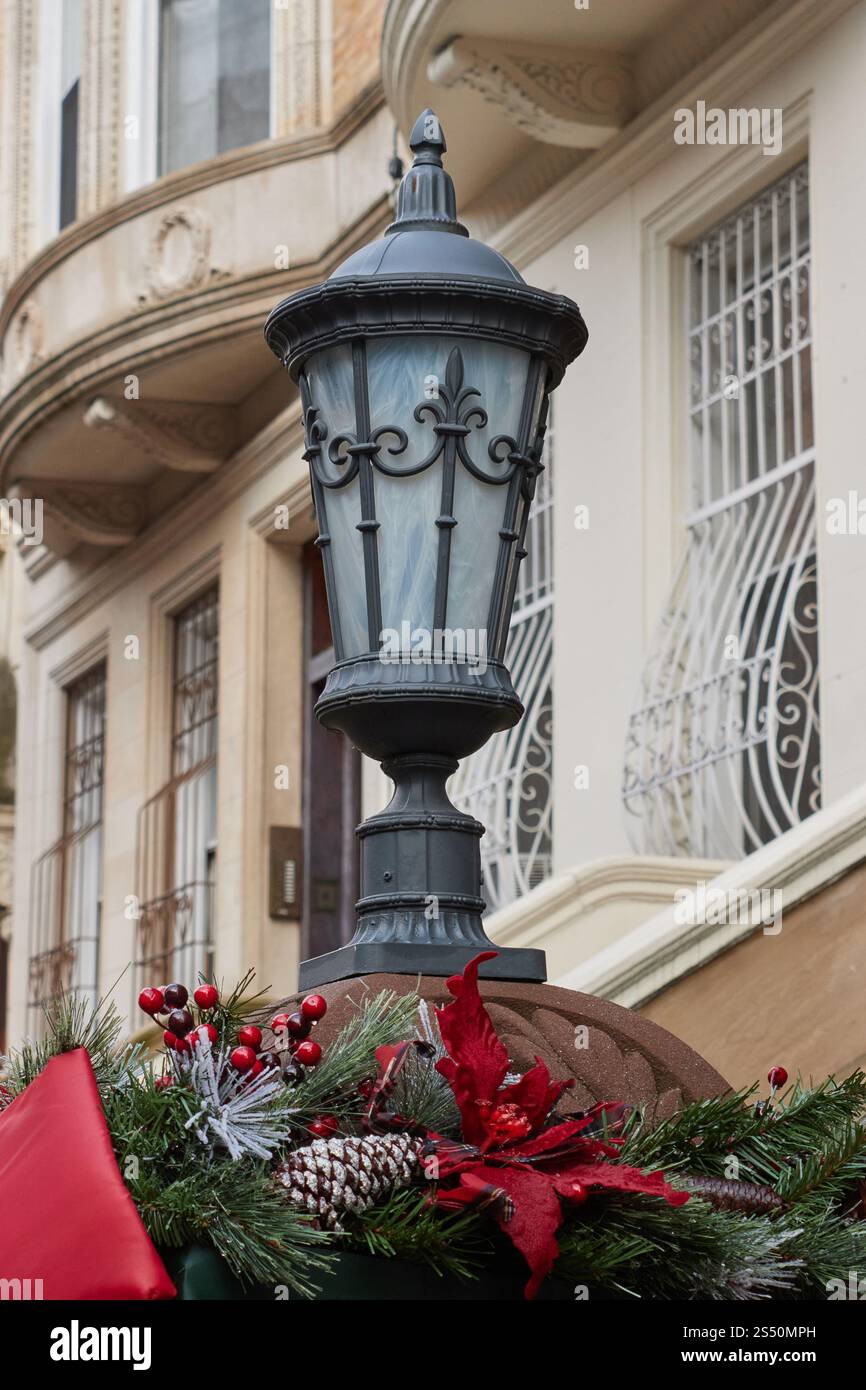 un luminaire de style victorien sur le tabouret extérieur des rowhouses victoriennes avec d'élégantes décorations de noël autour de la base Banque D'Images
