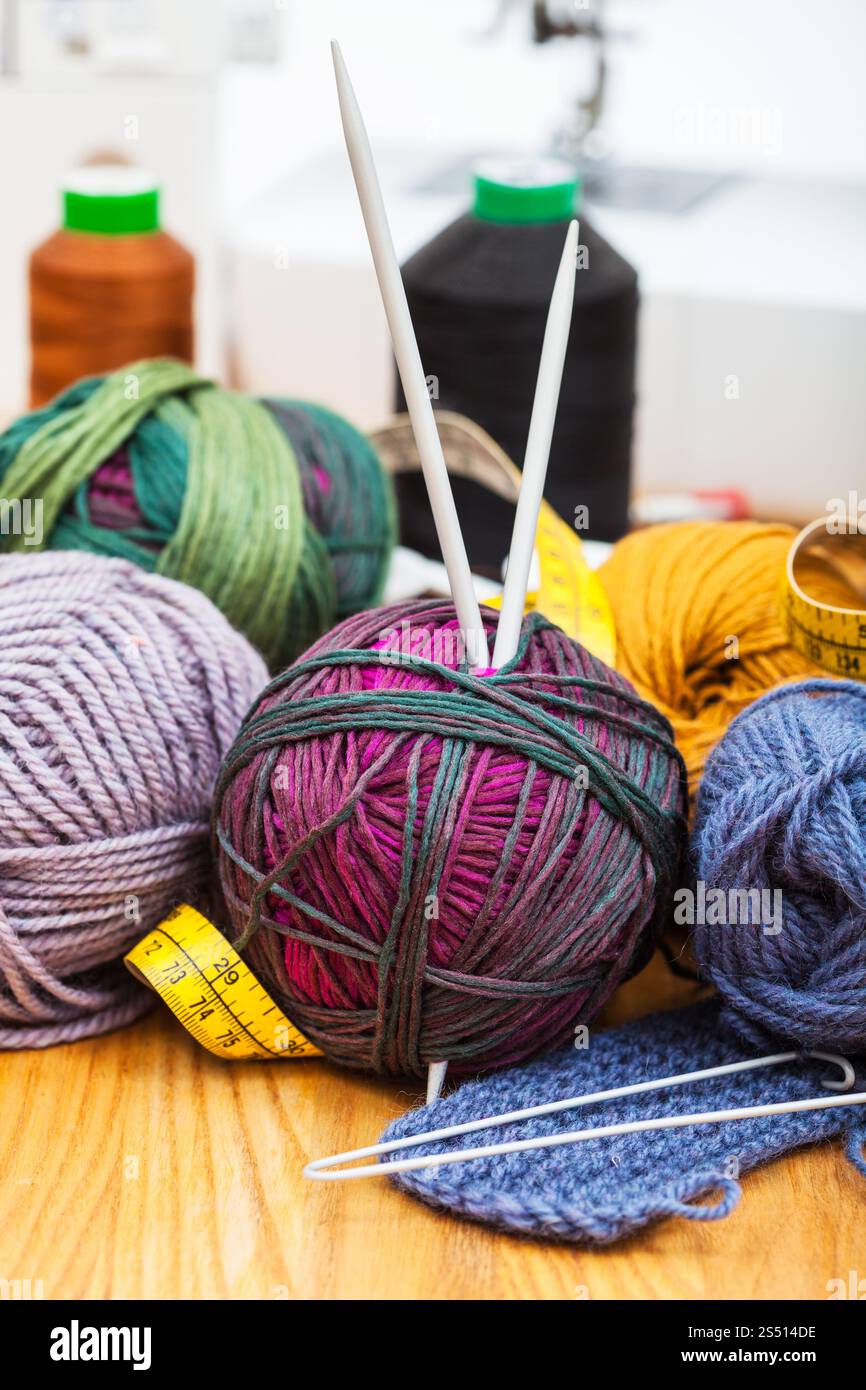 La vie encore d'aiguille à tricoter à la main - et les outils de couture sur la table et les machines à coudre sur l'arrière-plan Banque D'Images