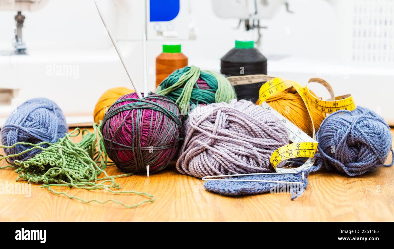 La vie encore de couture - divers outils de tricot sur la table et les machines à coudre sur l'arrière-plan Banque D'Images