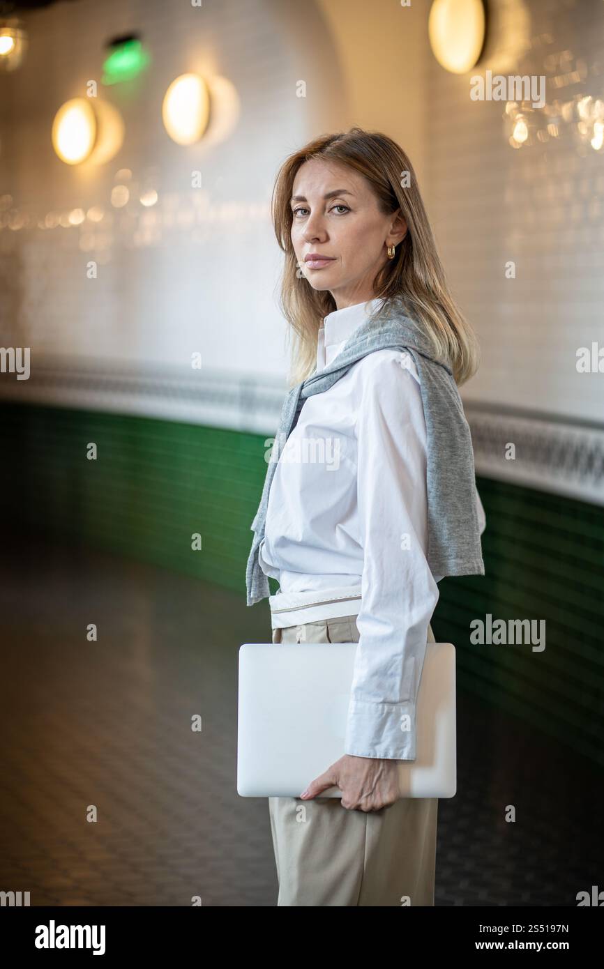 Femme d'affaires sérieuse debout dans le couloir de bureau avec tablette, regardez la caméra. Entrepreneur, journée de travail Banque D'Images