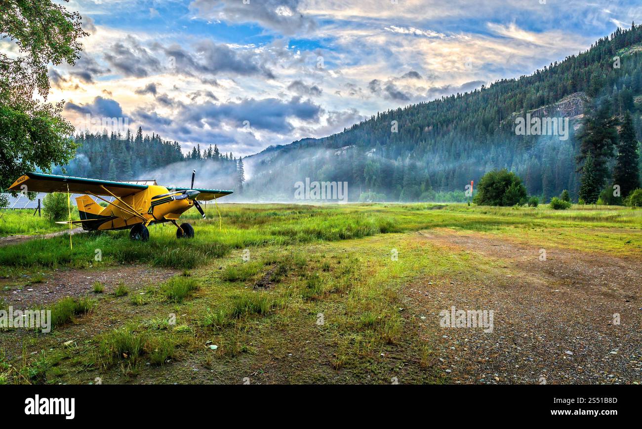 Avion jaune sur la piste Grass au milieu d'un paysage de montagne panoramique, Eagle Cap Wilderness, Oregon Banque D'Images