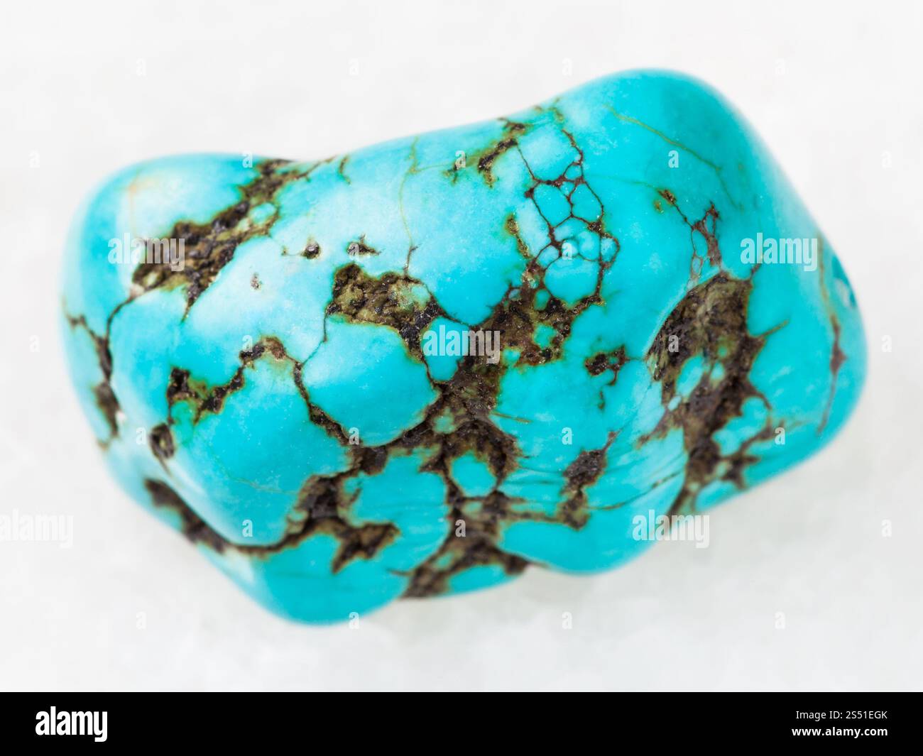 La prise de vue macro des eaux minérales naturelles rock specimen - howlite bleu poli (turquenite) gem stone sur fond de marbre blanc Banque D'Images