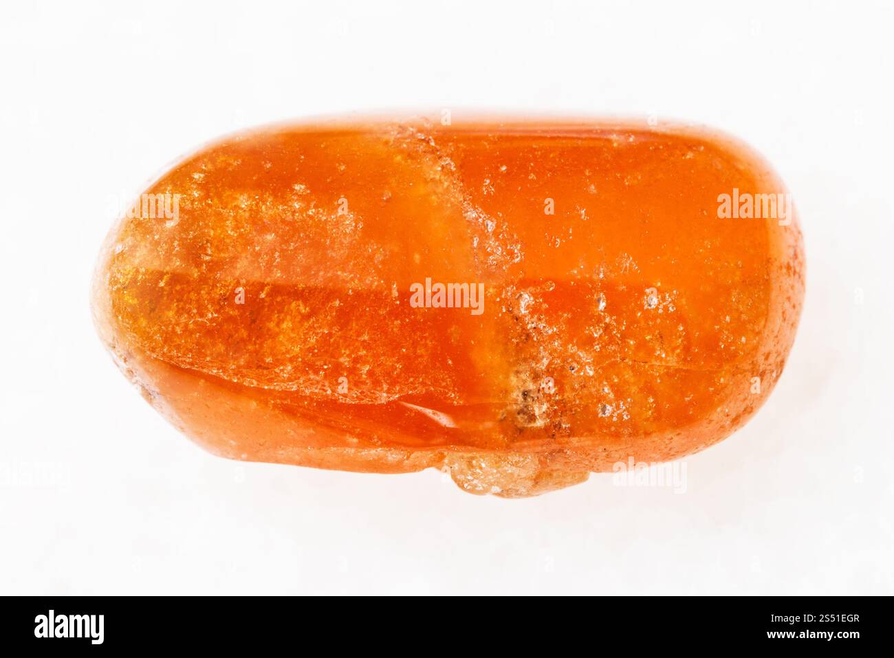 La prise de vue macro des eaux minérales naturelles rock specimen - tumbled grenat Spessartine gemstone sur fond de marbre blanc Banque D'Images