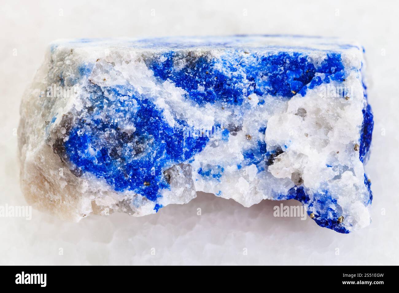 La prise de vue macro des eaux minérales naturelles et des matières premières - l'échantillon de roche en pierre lapis-lazuli sur fond de marbre blanc de Ljadvar-Dara, montagnes du Pamir, au Tadjikistan Banque D'Images