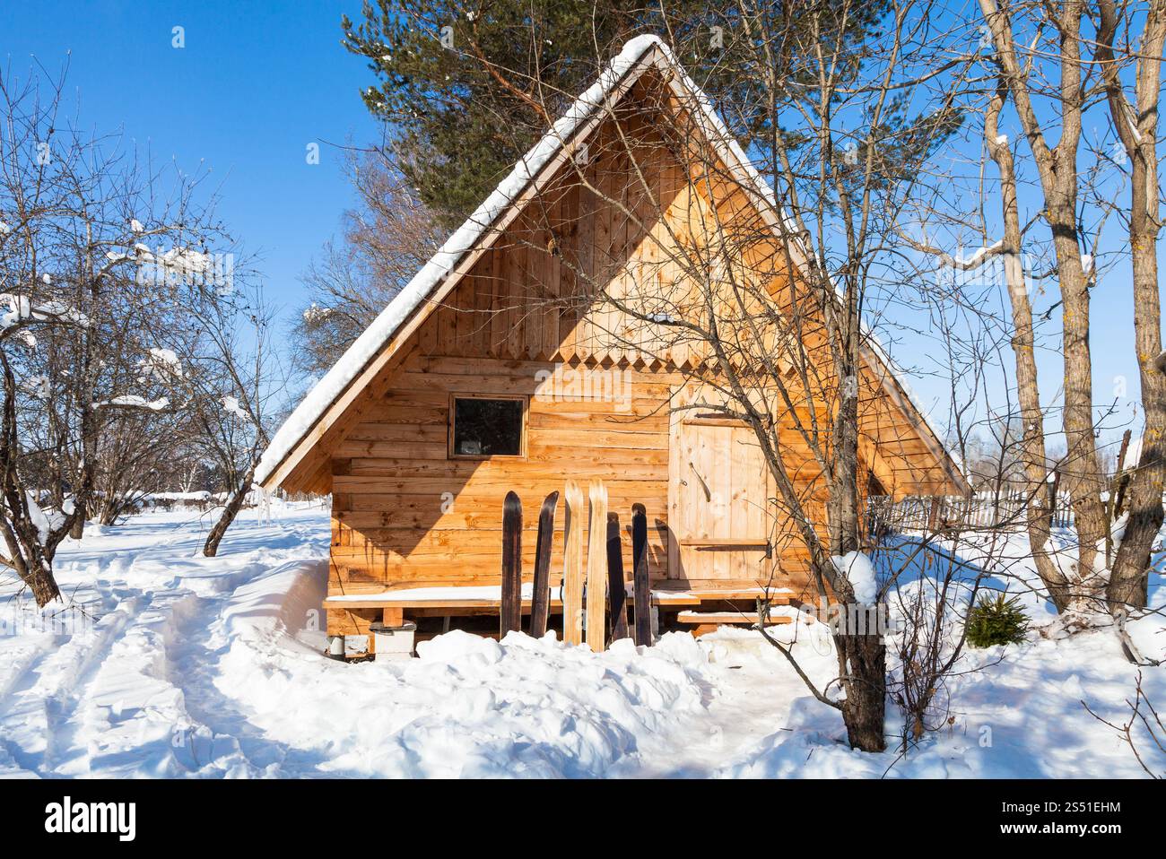 vue sur un petit chalet en bois et de larges skis. Vue sur un petit chalet en bois et de larges skis dans la journée ensoleillée d'hiver dans la région de Smolensk en Russie Banque D'Images