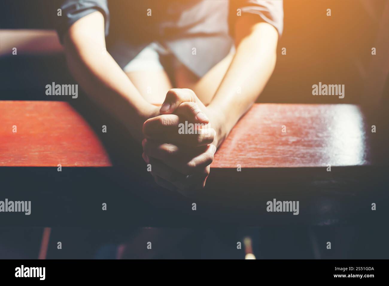 Prier femme assis sur un banc. Banque D'Images