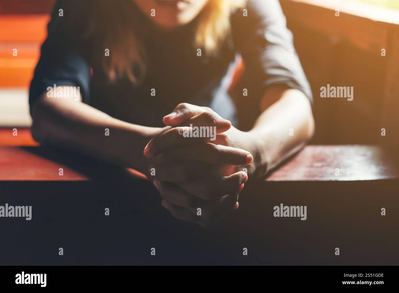 Prier femme assis sur un banc. Banque D'Images