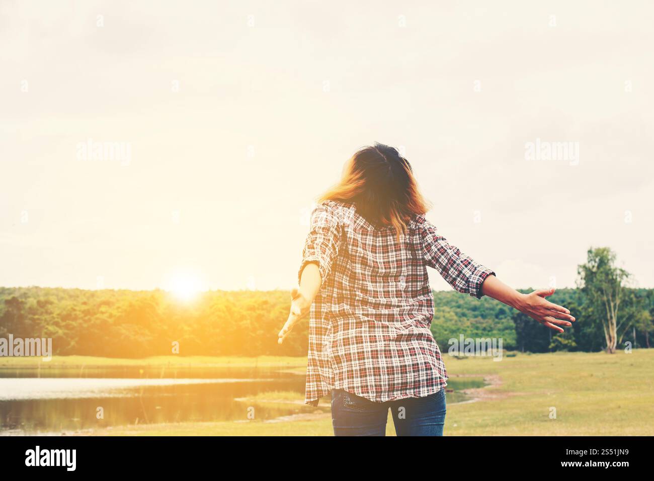 Concept de style de vie de la femme : jeune belle femme étirant les mains dans l'air profiter de l'air frais en dehors de la nature. Concept de style de vie de la femme : jeune Banque D'Images