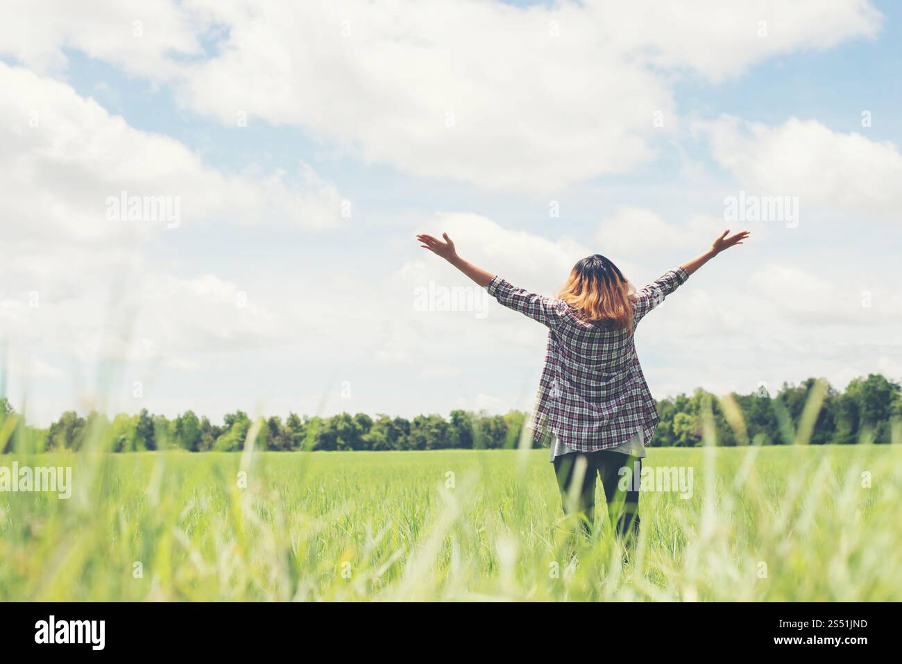 Liberté jeune belle femme étirant ses bras dans le ciel profiter et heureux avec l'air frais à la prairie. Liberté jeune belle femme qui s'étire Banque D'Images