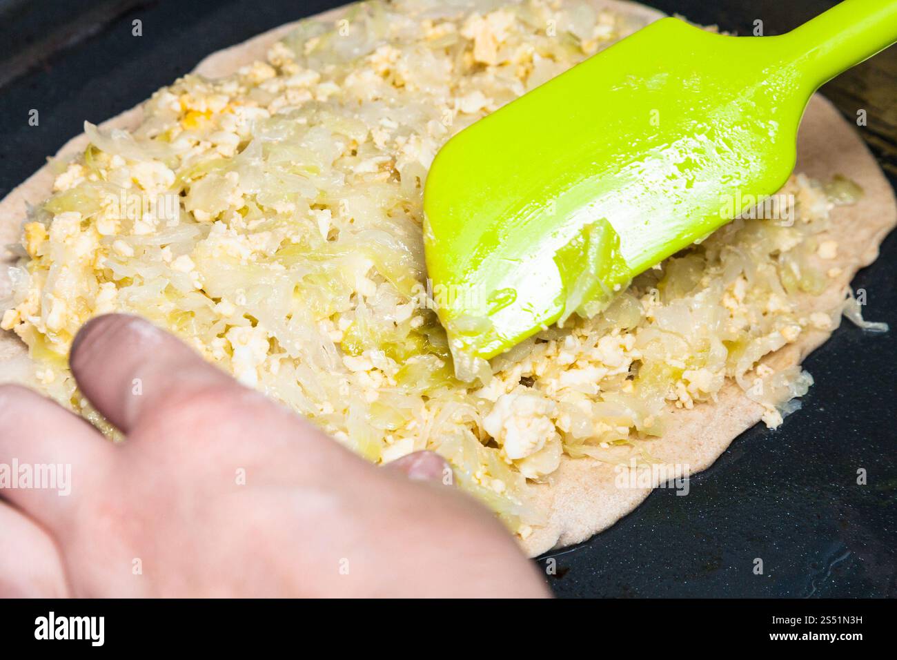 La cuisson de la tarte - diffusion de la farce de la coque et le chou braisé sur la feuille de pâte Banque D'Images