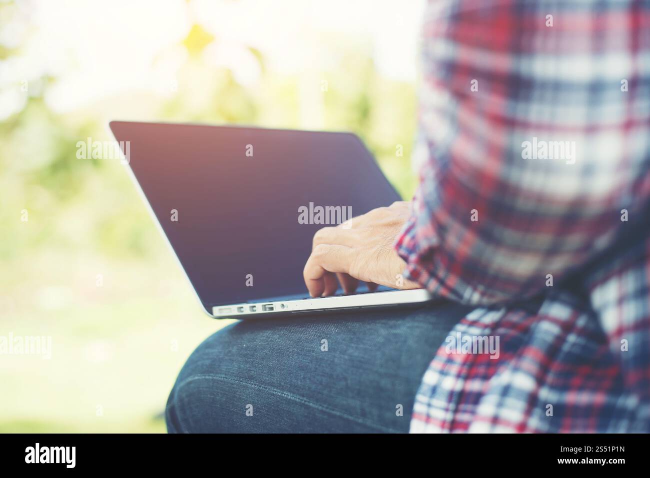 Jeune homme hipster travailler sur ordinateur au parc dans une journée ensoleillée. Banque D'Images Jeune homme hipster travailler sur ordinateur au parc dans une journée ensoleillée. Banque D'Images
