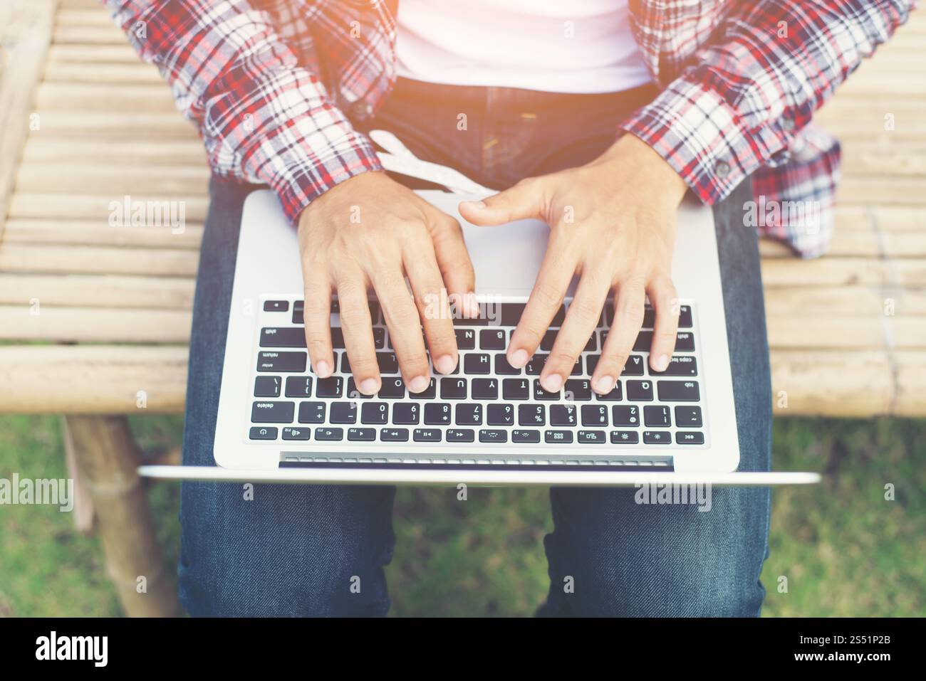 Jeune homme hipster travailler sur ordinateur au parc dans une journée ensoleillée. Banque D'Images Jeune homme hipster travailler sur ordinateur au parc dans une journée ensoleillée. Banque D'Images