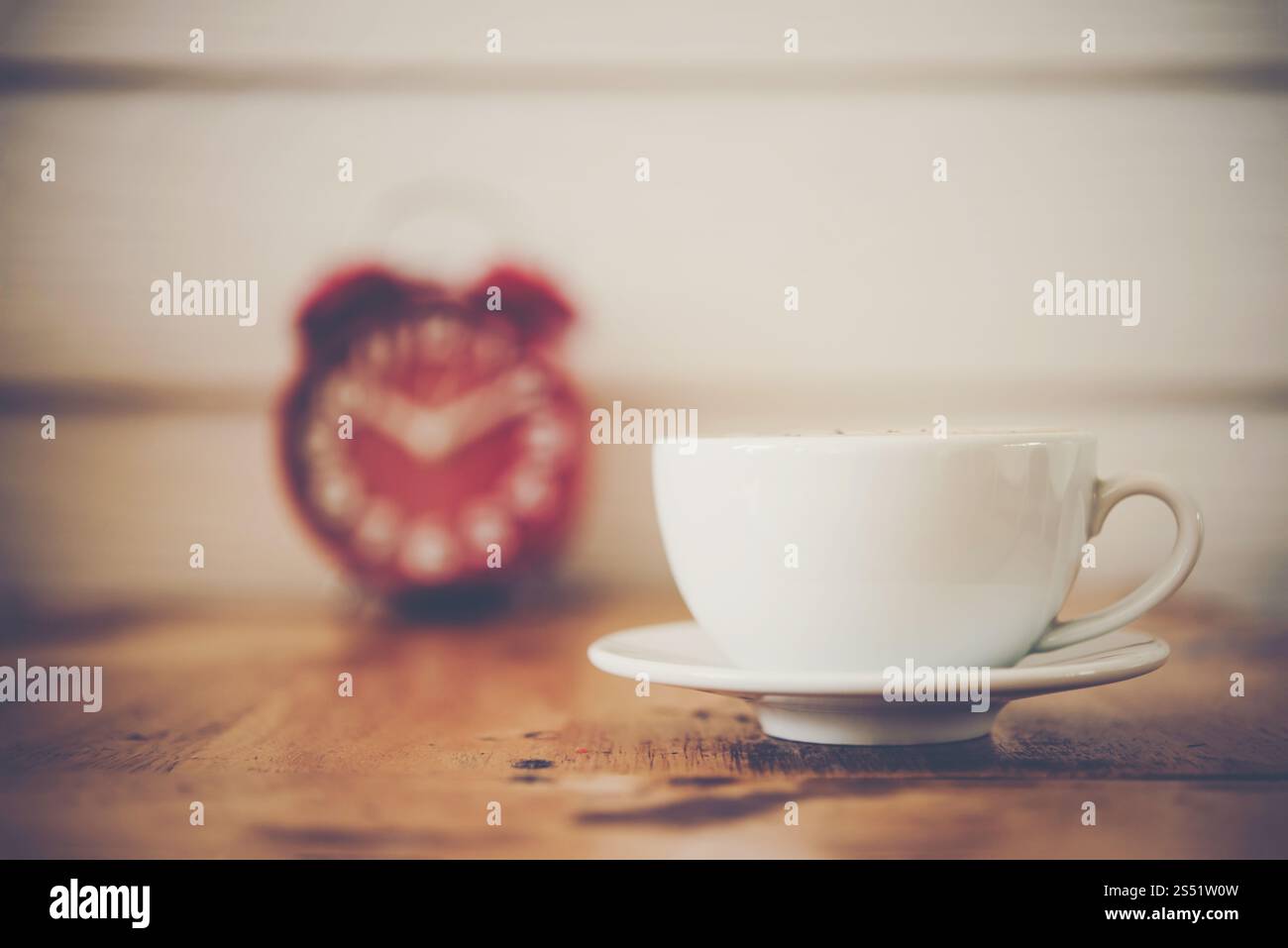 Réveil rouge avec du café sur table en bois. Pause café. Banque D'Images