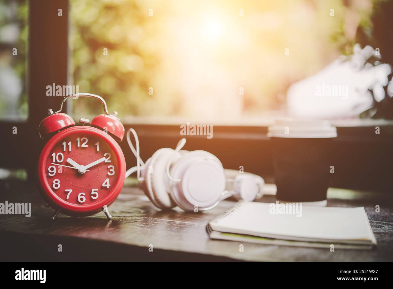 Tasse de papier de café, ordinateur portable et réveil rouge avec casque. Tasse de papier de café, ordinateur portable et réveil rouge avec casque sur la table en bois, Banque D'Images