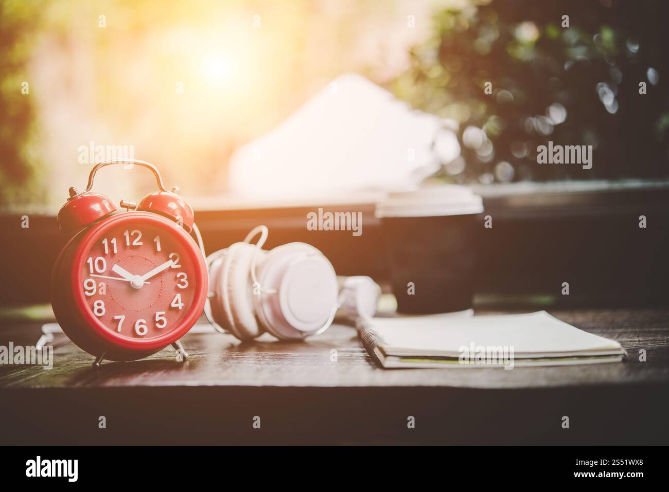 Tasse de papier de café, ordinateur portable et réveil rouge avec casque. Tasse de papier de café, ordinateur portable et réveil rouge avec casque sur la table en bois, Banque D'Images