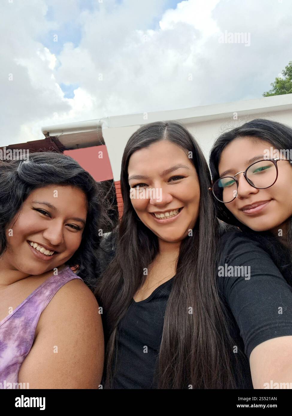 Trois femmes latines brunes utilisent des téléphones portables pour passer des appels vidéo et prendre des photos de selfie, profiter et passer du temps de qualité Banque D'Images