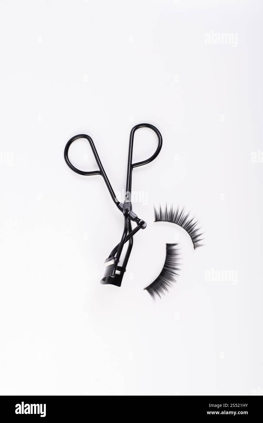 Faux faux cils avec curler isolé sur fond blanc. Banque D'Images