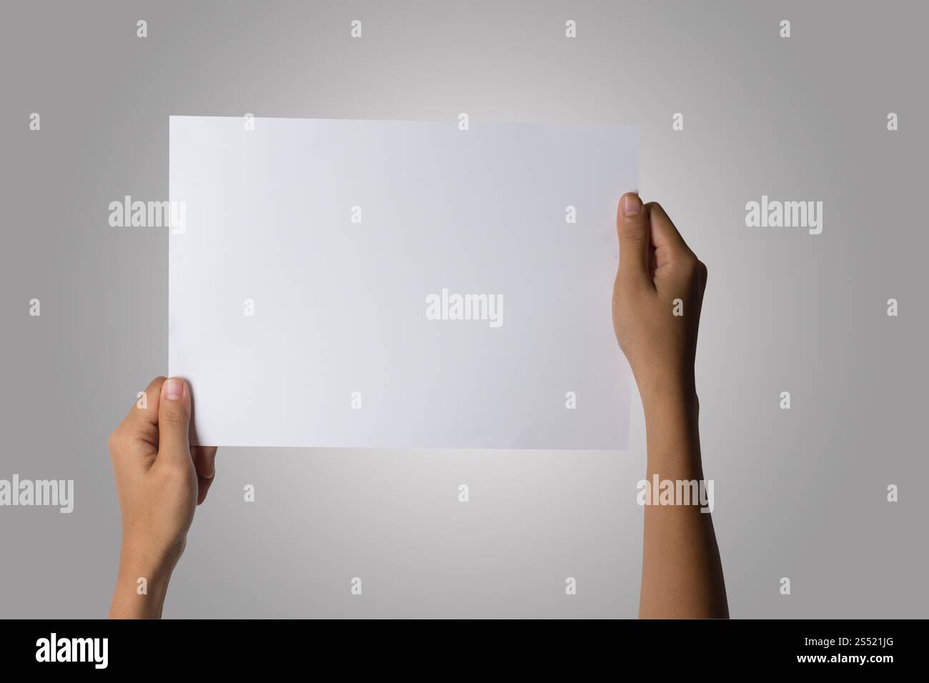 Gros plan de la main de femme tenant du papier blanc isolé sur bac blanc. Gros plan de la main de femme tenant du papier blanc isolé sur fond blanc Banque D'Images