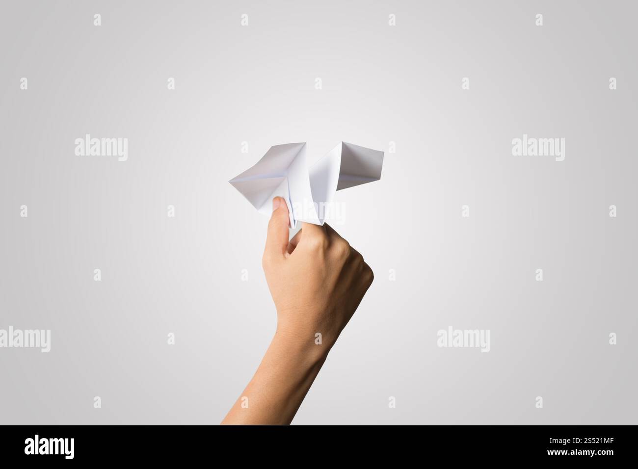 Avion de Papier Dart main femme isolé sur fond blanc. Banque D'Images