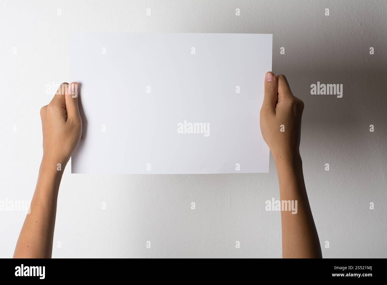 Gros plan de la main de femme tenant du papier blanc isolé sur bac blanc. Gros plan de la main de femme tenant du papier blanc isolé sur fond blanc Banque D'Images