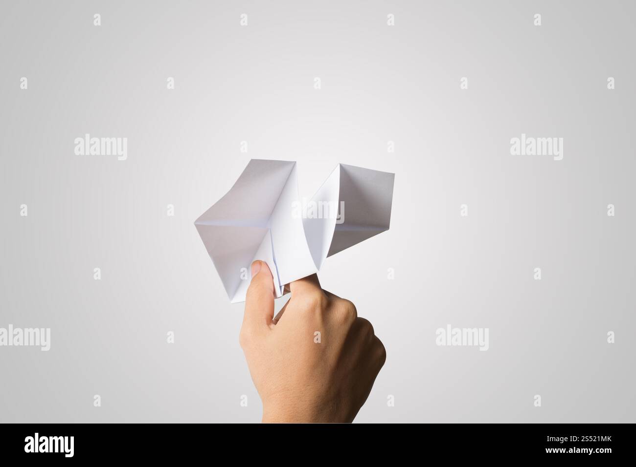 Avion de Papier Dart main femme isolé sur fond blanc. Banque D'Images