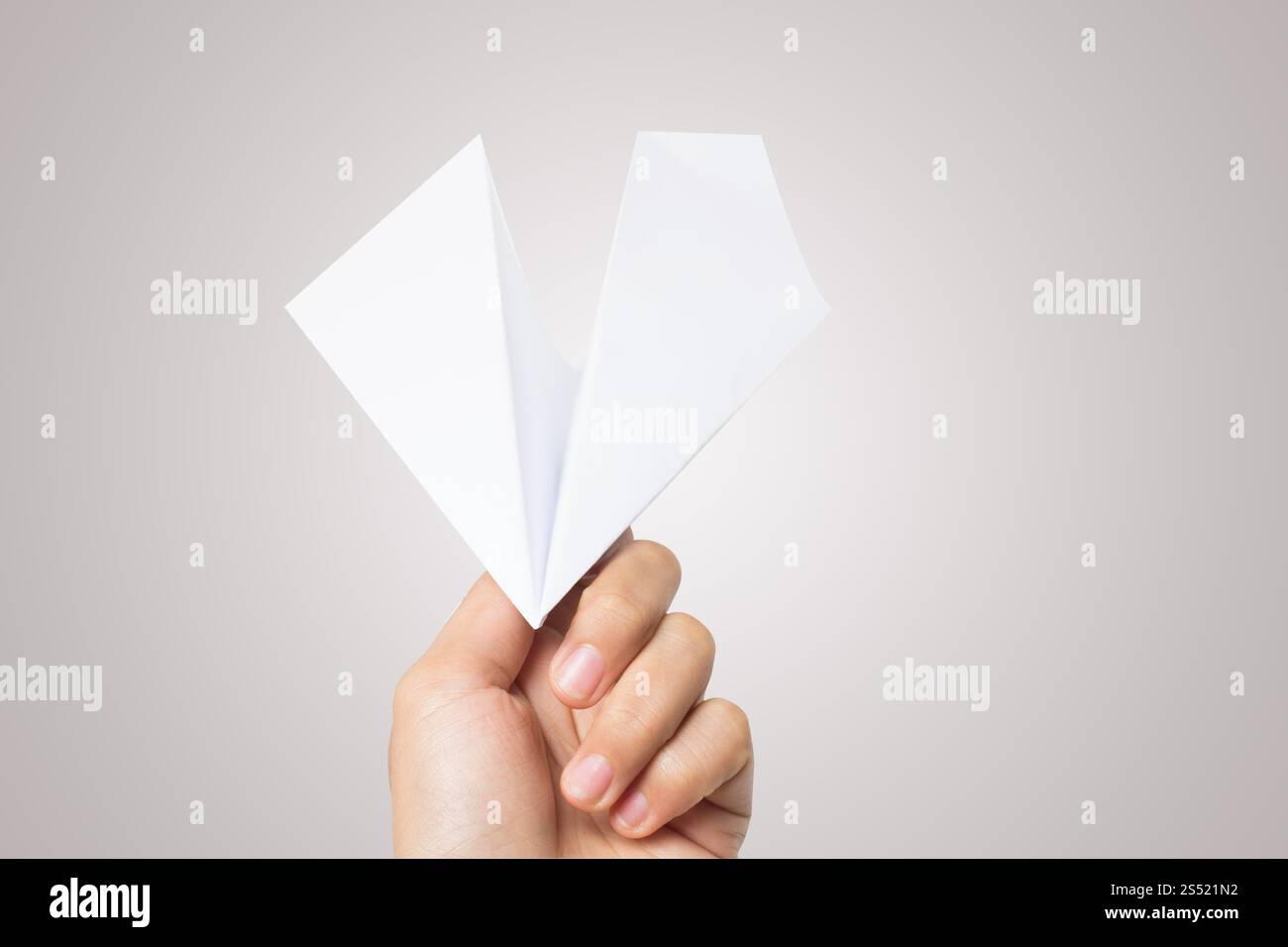 Avion de Papier Dart main femme isolé sur fond blanc. Banque D'Images