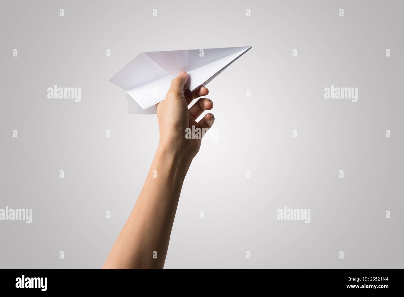 Avion de Papier Dart main femme isolé sur fond blanc. Banque D'Images