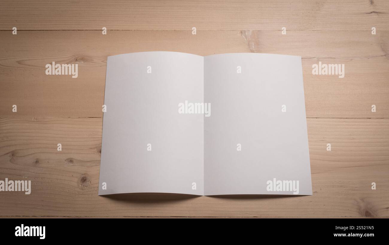 Le bloc-notes de papier blanc vide sur la table en bois. Banque D'Images