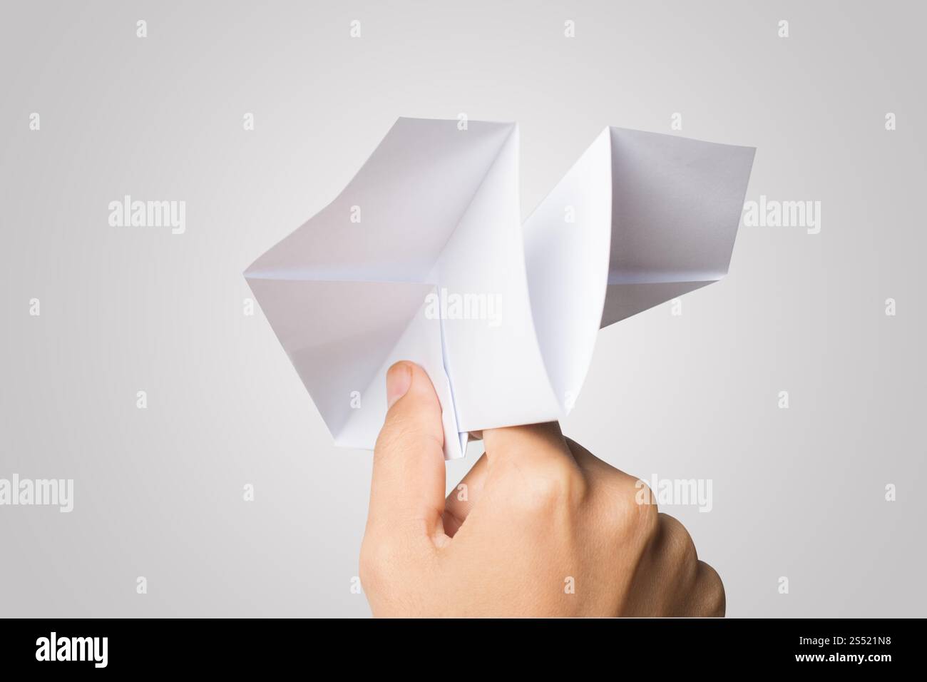 Avion de Papier Dart main femme isolé sur fond blanc. Banque D'Images