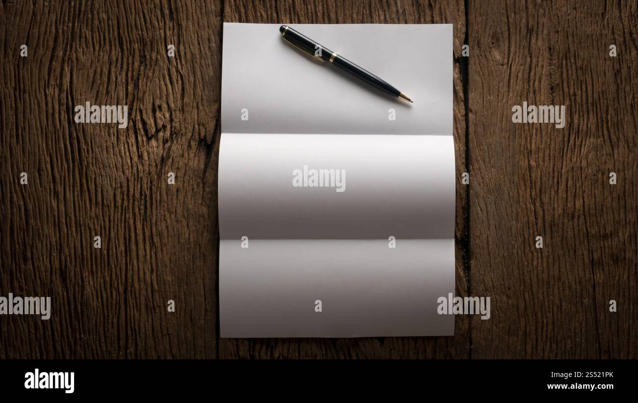 Feuille blanche de papier et stylo sur la table en bois. Feuille blanche de papier et stylo sur la table en bois. Banque D'Images