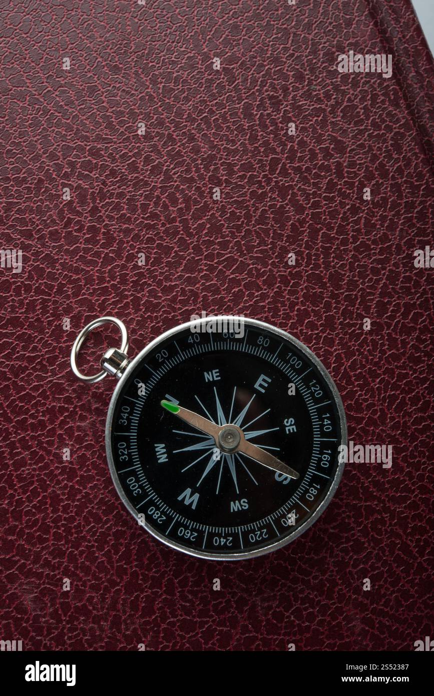Plus de boussole sur fond de cuir rouge. Concept de voyage. Banque D'Images