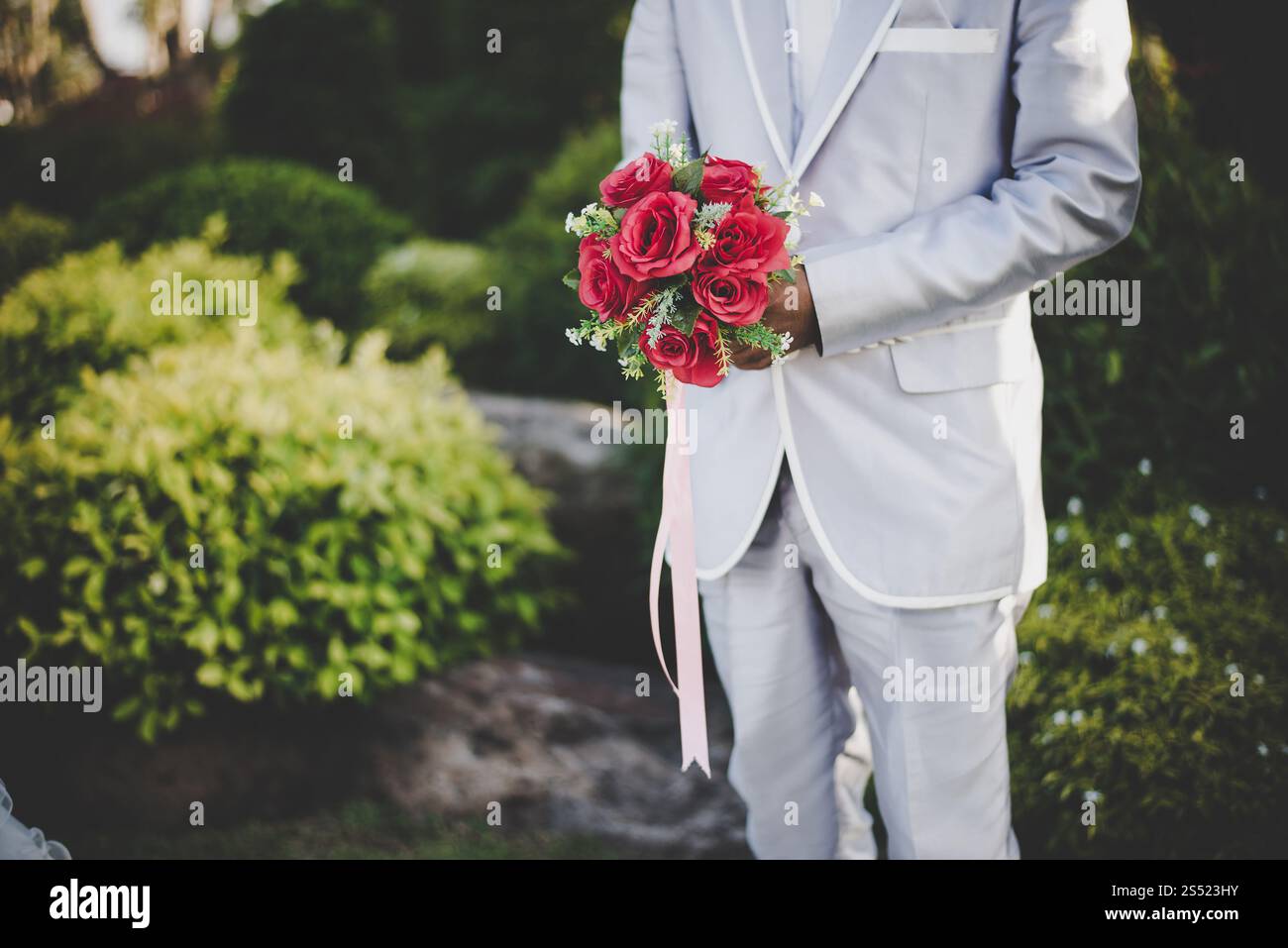 Marié avec bouquet de rose rouge. Banque D'Images