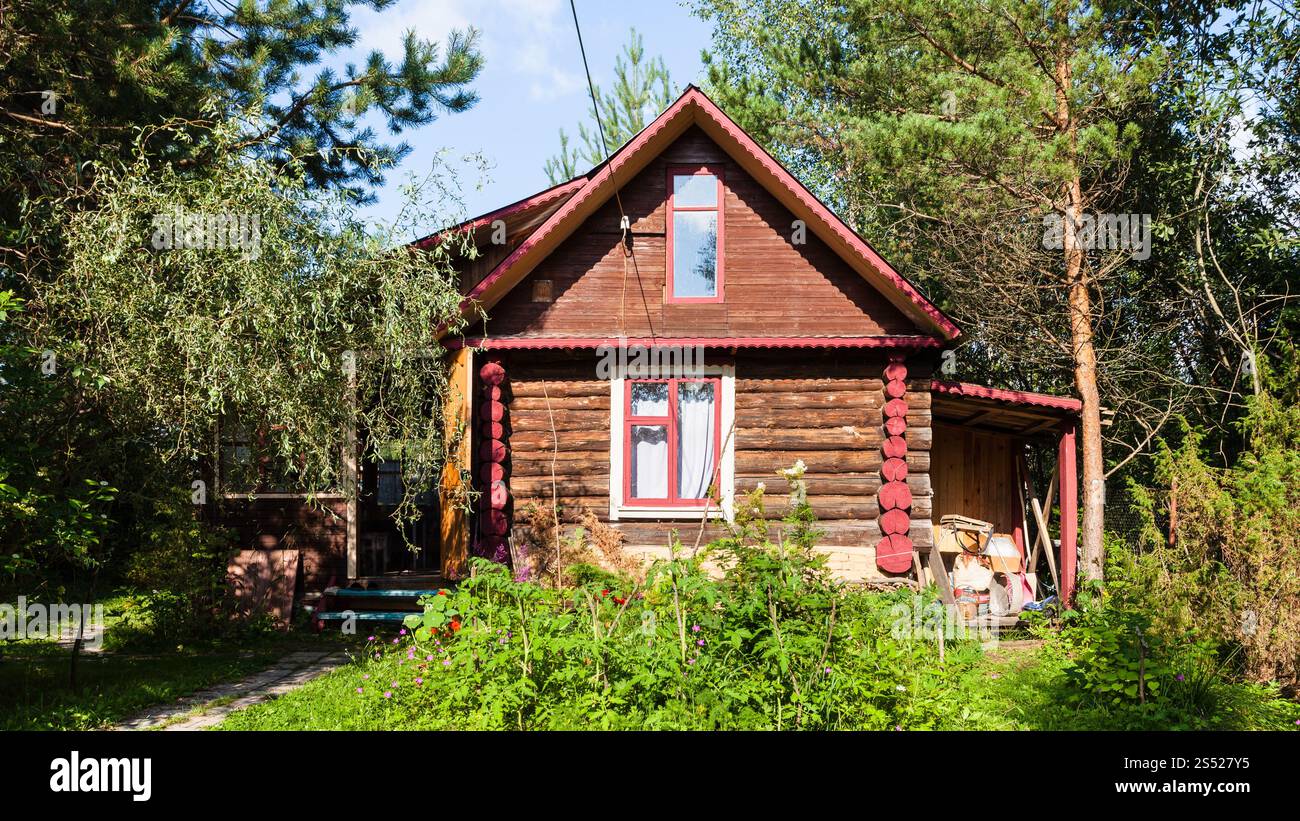 Maison rurale en rondins dans le jardin vert le jour ensoleillé d'été dans la région de Tver en Russie Banque D'Images