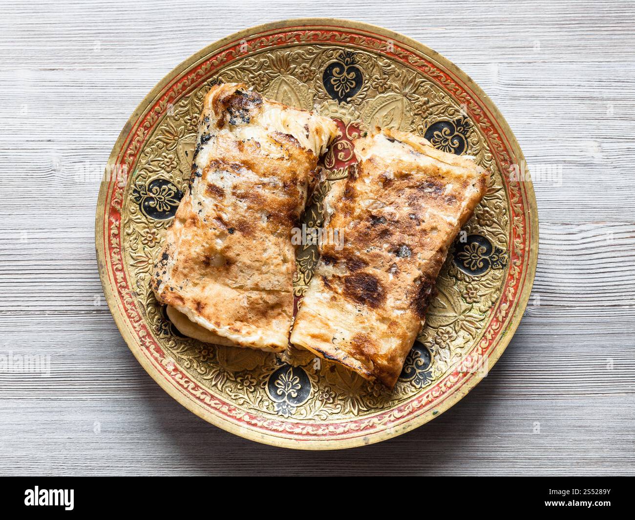 La cuisine indienne - Beurre de laminés plats naan pain cuit au tandoor avec du beurre sur plaque en laiton Banque D'Images