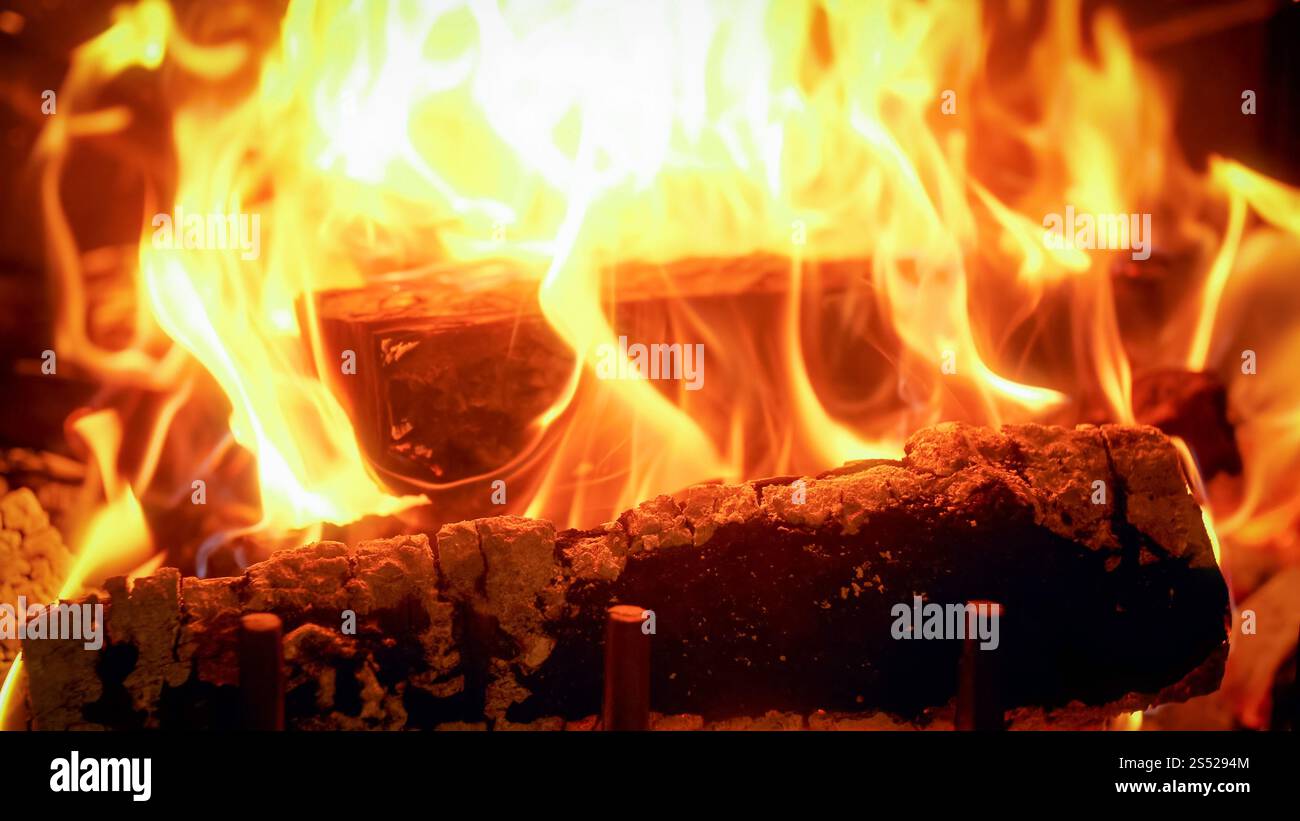 Gros plan photo de flammes de feu provenant de bûches de bois brûlées. Gros plan de flammes de feu provenant de bûches de bois brûlées Banque D'Images