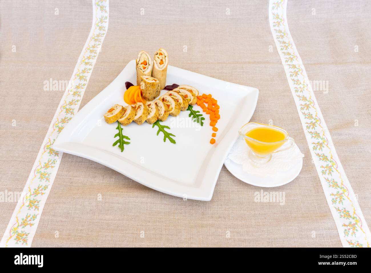 Un plateau de fruits de mer gastronomique magnifiquement arrangé avec des fruits de mer roulés avec des garnitures colorées. Le plat est servi sur une assiette blanche, en soulignant son Banque D'Images