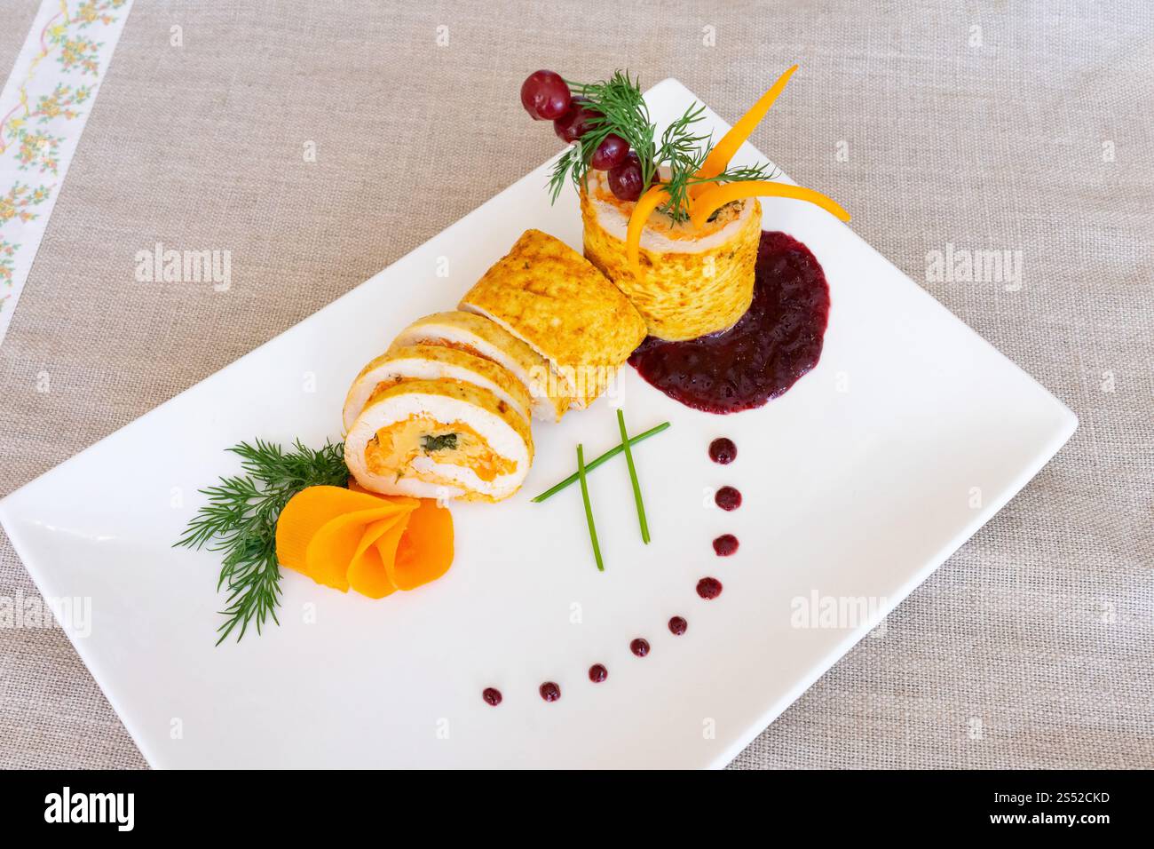 Un plat magnifiquement arrangé comprend des rouleaux de sushi faits avec des ingrédients frais, garnis d'herbes et de légumes colorés. Une présentation unique ajoute Banque D'Images