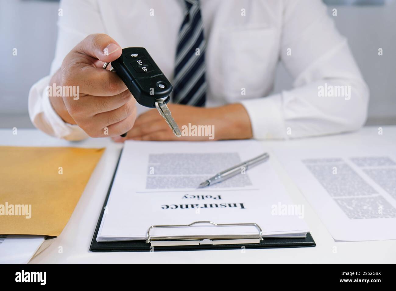 Le vendeur de voitures distribue les clés d'une nouvelle voiture Banque D'Images Le vendeur de voitures distribue les clés d'une nouvelle voiture Banque D'Images