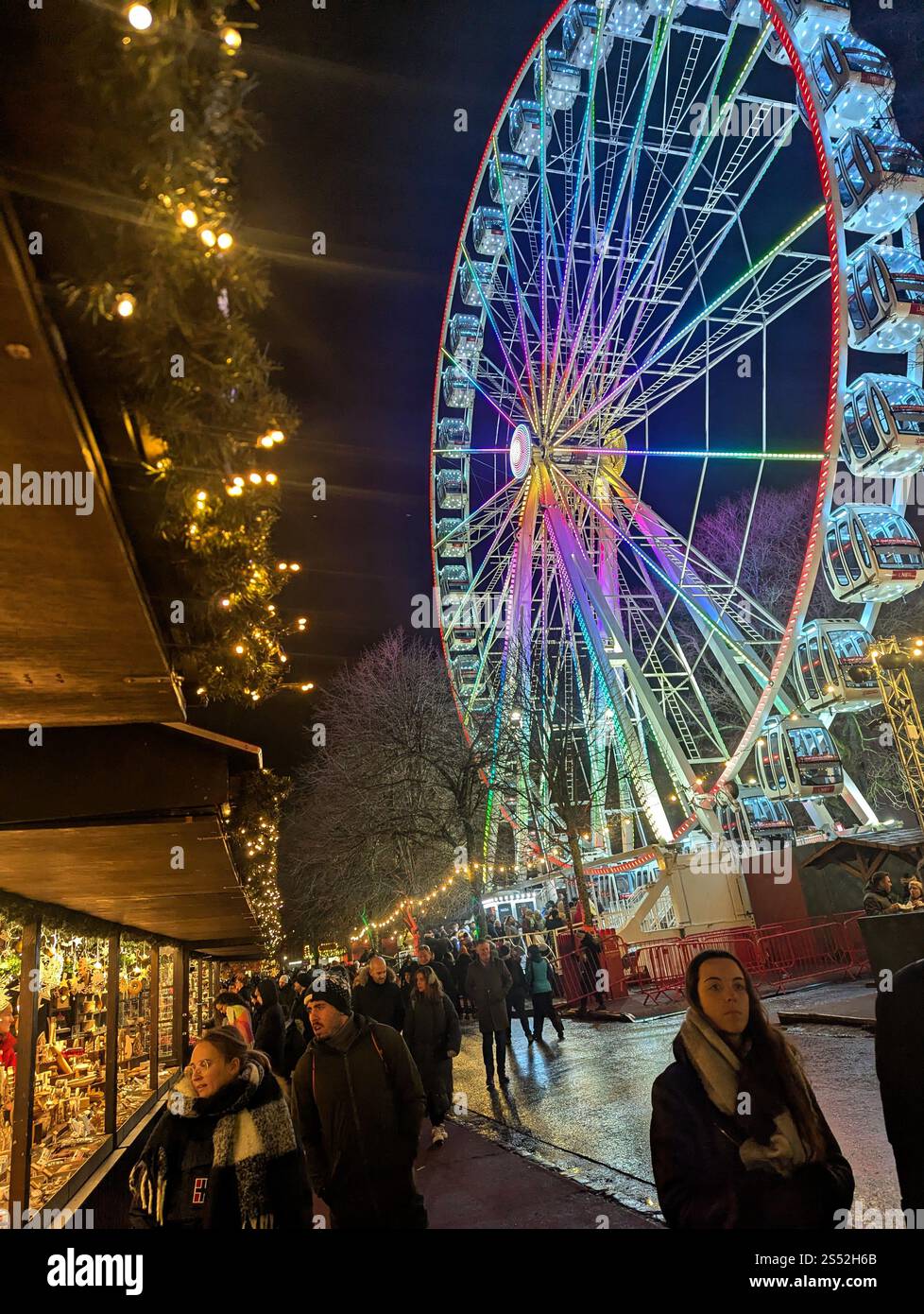 Vibes festives et lumières éblouissantes ! Une nuit magique au marché de vacances, avec un magnifique tour de roue en grande roue. Banque D'Images