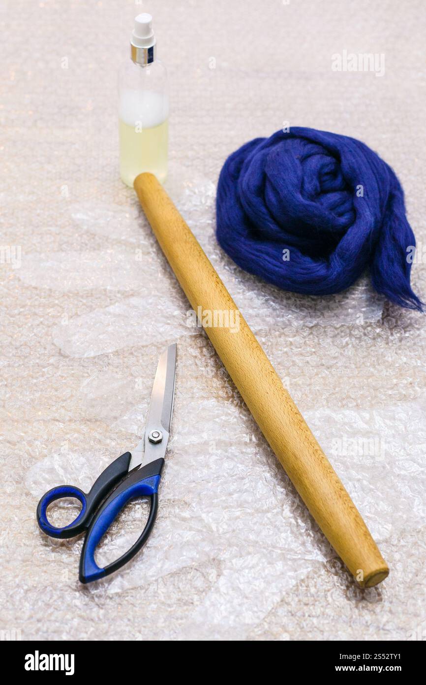 La main de l'atelier faisant un Gants polaire à partir de la laine mérinos à l'aide de feutrage humide - laine et un ensemble d'outils pour faire du feutre sur carton mat Banque D'Images