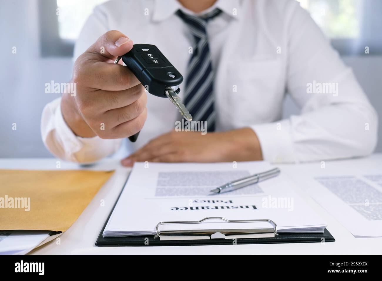 Le vendeur de voitures distribue les clés d'une nouvelle voiture Banque D'Images Le vendeur de voitures distribue les clés d'une nouvelle voiture Banque D'Images