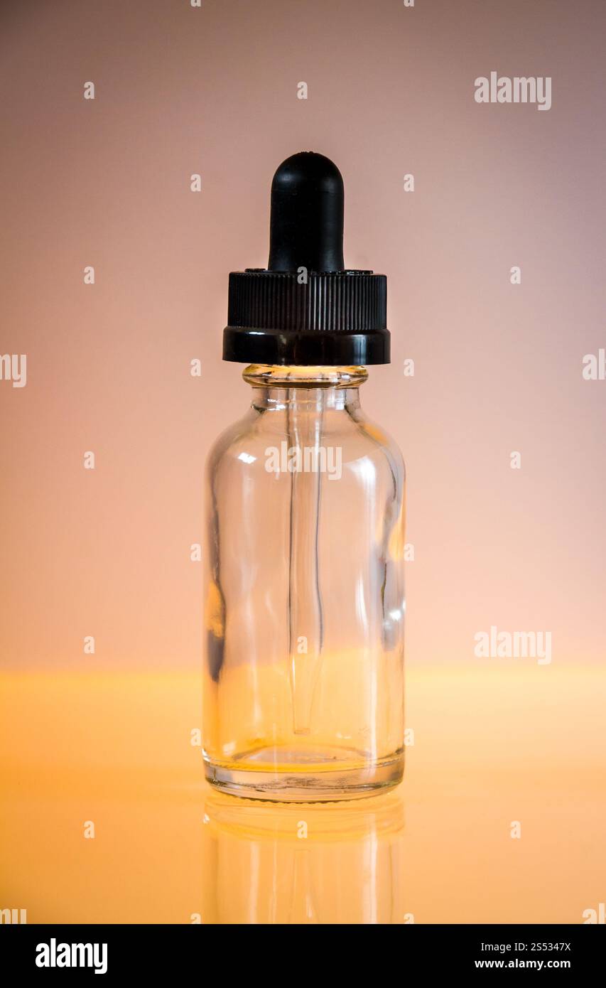 Bouteille compte-gouttes en verre et pipette sur fond orange. Bouteille compte-gouttes en verre sur fond orange Banque D'Images