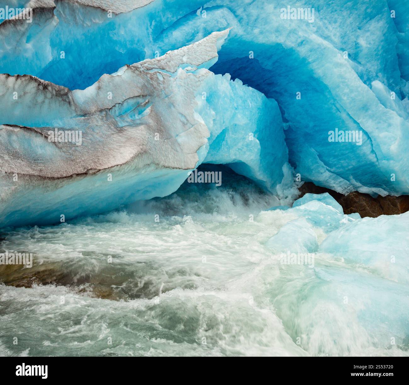Vue rapprochée de la grotte de pied du glacier Nigardsbreen et du ruisseau de glace fondante, Jostedal, Norvège. Belle glace glaciaire naturelle et fond de début de rivière Banque D'Images