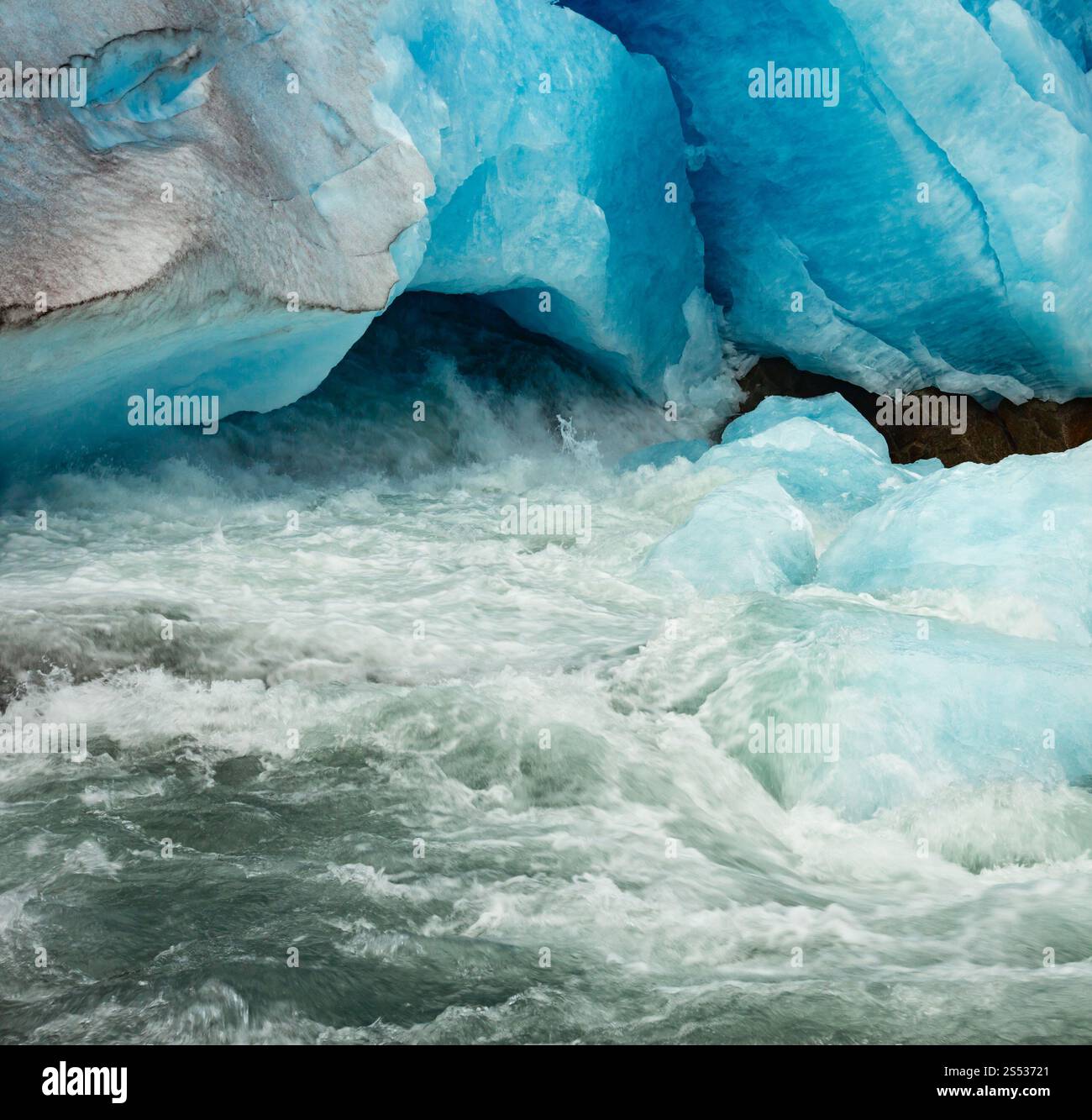 Vue rapprochée de la grotte de pied du glacier Nigardsbreen et du ruisseau de glace fondante, Jostedal, Norvège. Belle glace glaciaire naturelle et fond de début de rivière Banque D'Images