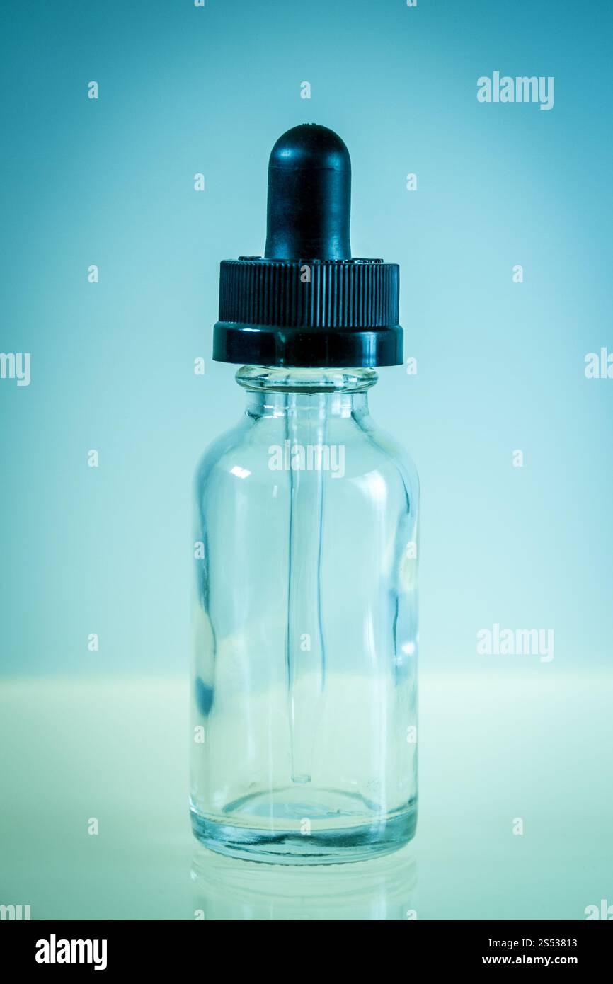 Bouteille compte-gouttes en verre et pipette sur fond bleu. Bouteille compte-gouttes en verre sur fond bleu Banque D'Images