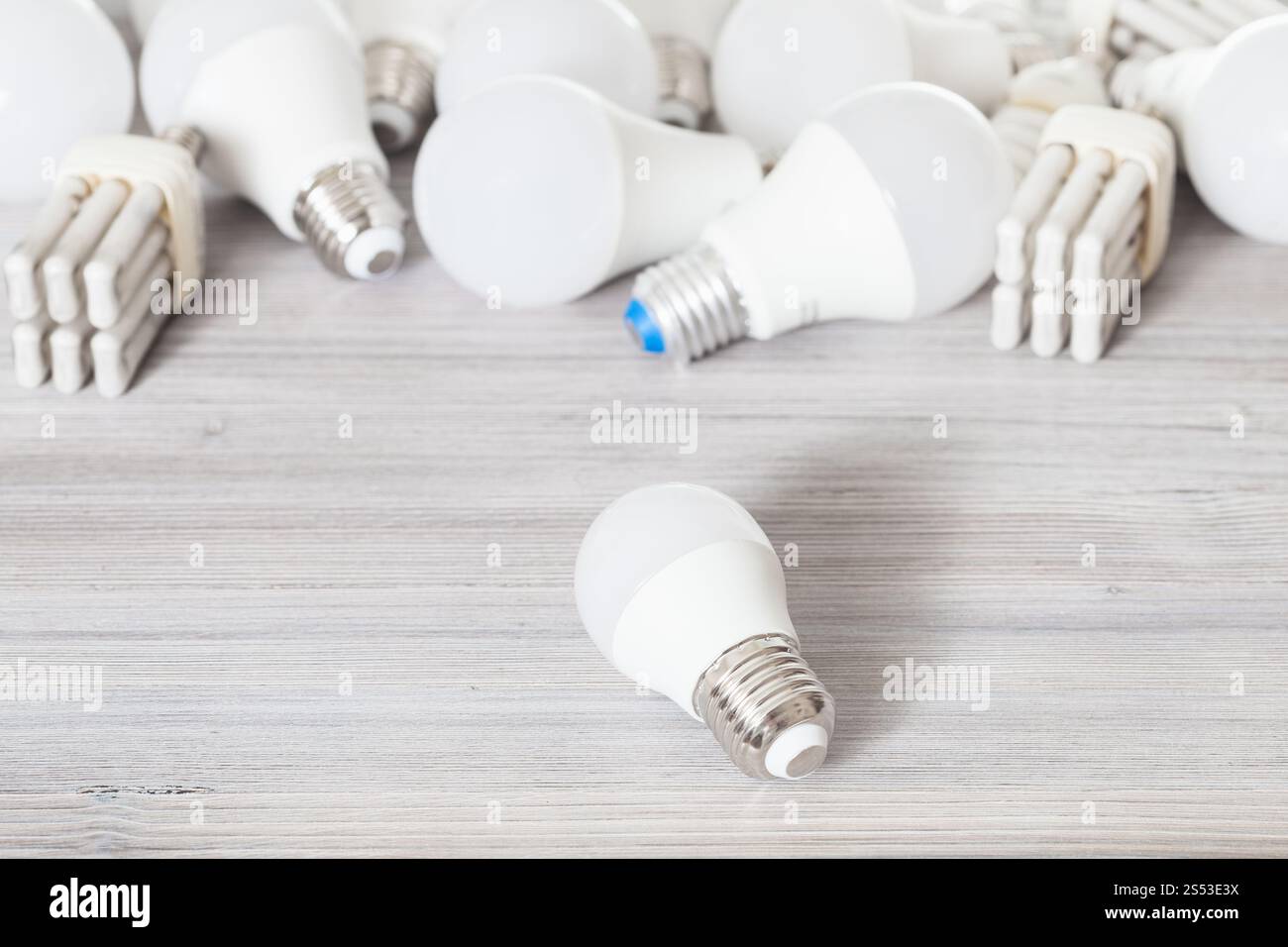 Une ampoule LED blanc et divers sur les lampes à économie d'énergie conseil en bois gris Banque D'Images